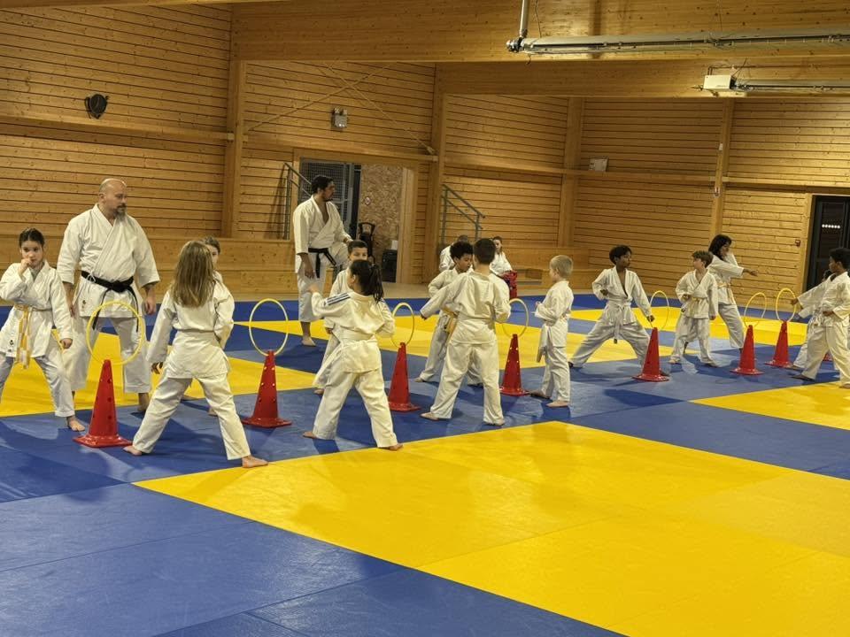 Deux professeurs encadrent un cours de karaté pour enfants